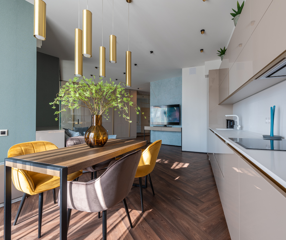 A modern, staged home with clear benches and some greenery in a vase on the dining table