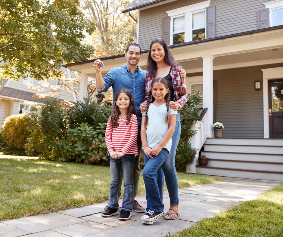 A family stands outside their new home.