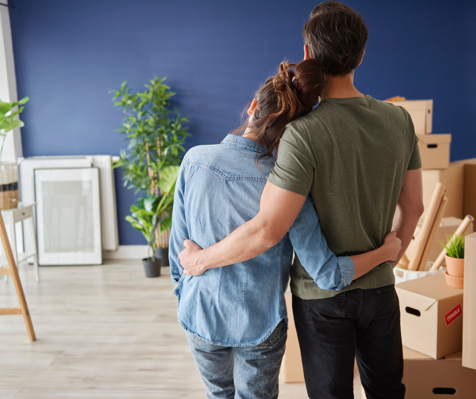 Rentvesting couple with their arms around each other looking at their home