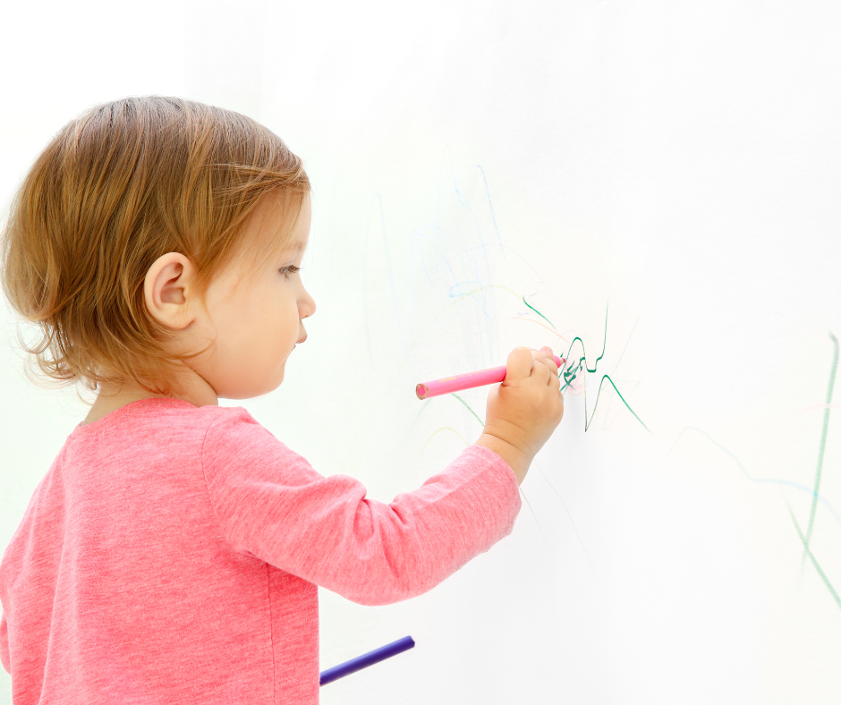 Toddler draws on a white wall